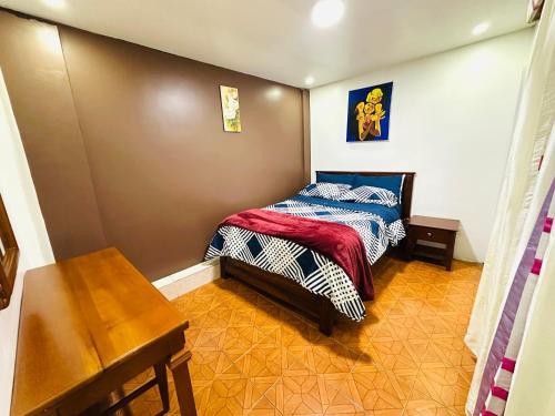 a small bedroom with a bed and a table at Confort Home Apartamentos Vacacionales in Baños
