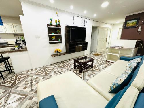a living room with a couch and a tv at Confort Home Apartamentos Vacacionales in Baños