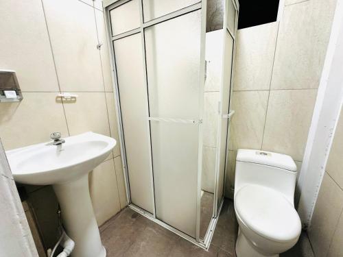 a bathroom with a toilet and a sink at Confort Home Apartamentos Vacacionales in Baños