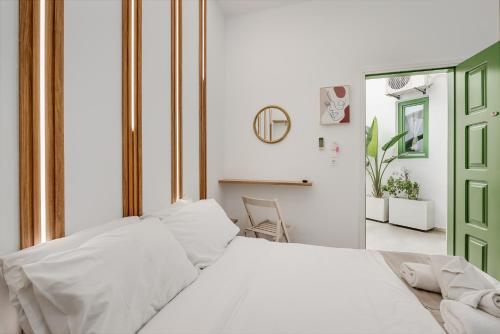 a bedroom with a white bed and a green door at Vincenzo Harmony II- Rethymno old town in Rethymno Town