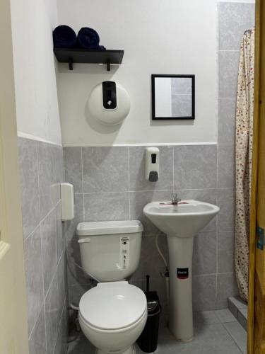 a bathroom with a toilet and a sink at D Calles Place LA PUNTA in La Libertad