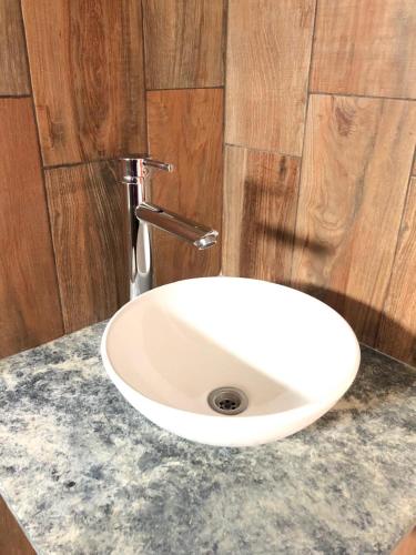 a white sink sitting on a counter in a bathroom at Departamentos Los Robles in Comodoro Rivadavia