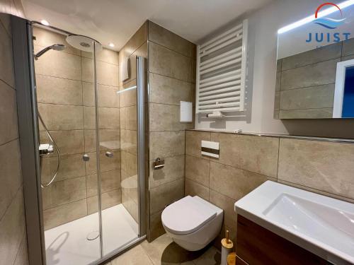 a bathroom with a shower and a toilet and a sink at Haus Inselresidenz Strandburg 301 - Wohnung 101 in Juist
