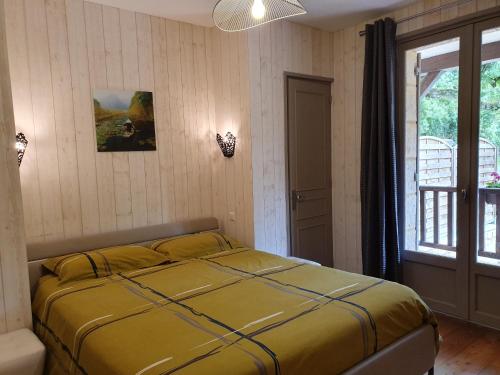 - une chambre avec un lit jaune dans l'établissement LA VILLA DES HAUTS DE SARLAT, à Sarlat-la-Canéda