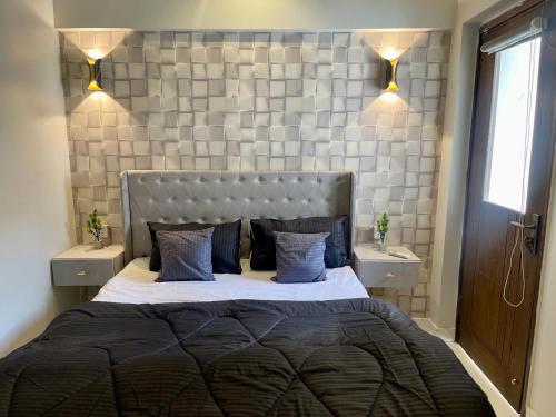 a bedroom with a large bed with blue pillows at Beachfront Studios by Virani in Karachi