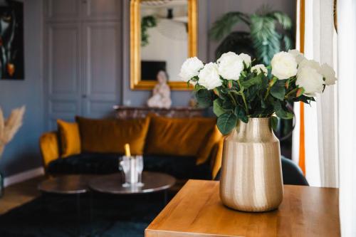 - un vase avec des fleurs blanches sur une table dans le salon dans l'établissement La Môme — Parking, quartier historique & animé, à Caen