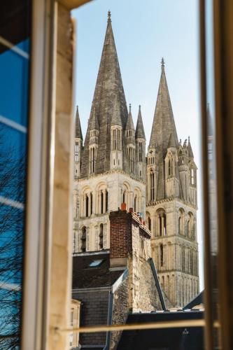 Elle offre une vue sur un grand bâtiment avec des tourelles. dans l'établissement La Casa Bella — Parking privé & vue sur l'abbaye, à Caen