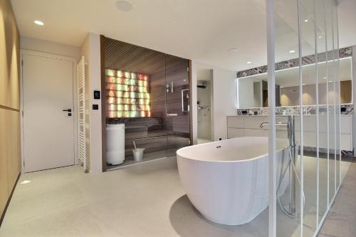 a bathroom with a large white tub in a room at Bee Happy Loft Welness in Huy
