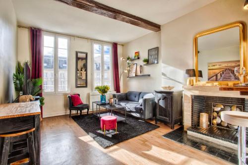 un salon avec un canapé et une cheminée dans l'établissement La Casa Bella — Parking privé & vue sur l'abbaye, à Caen