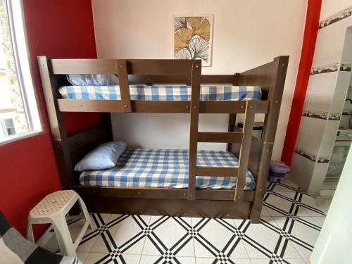 a bunk bed in a room with a bed in a room at Kitnet funcional perto da praia Ocian! in Samaritá