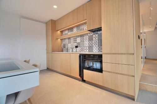 a kitchen with wooden cabinets and a washer and dryer at Bee Happy Loft Welness in Huy