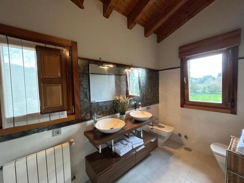 a bathroom with two sinks and a large mirror at Chalet Huerta de Cañamal - Llanes in Llanes