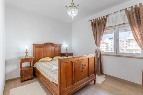 a bedroom with a wooden bed and a window at Casa de Rio Maior T3 in Rio Maior