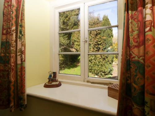 ein Fenster in einem Zimmer mit Blick auf einen Hof in der Unterkunft Anvil Cottage in Blakeney