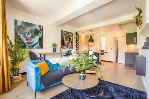 un salon avec un canapé bleu et une table dans l'établissement Appartement avec vue sur le château, à Caen