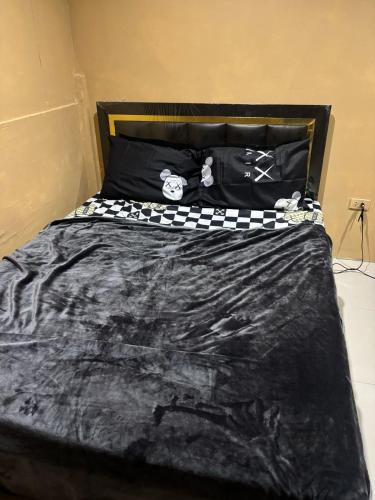a bed with a black and white comforter on it at Stay Inn in Pattaya Central