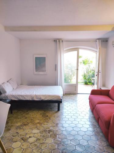 une chambre avec un lit, un canapé et une fenêtre dans l'établissement Studio 3 - LES SUITES DE ROBINSON - Résidence avec piscine en bord de Siagne, à Mandelieu-La-Napoule, à Mandelieu-la-Napoule