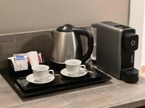 a coffee pot and two cups on a tray next to a printer at Sunset Guest House in Reggio Calabria