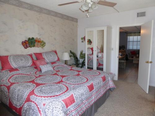 een slaapkamer met een bed met een rode en witte sprei bij PlayaBlanco Suites in Fort Lauderdale