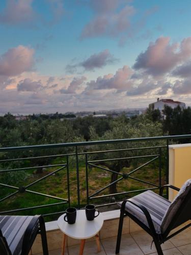 a balcony with two chairs and a table and a view at Olive Heaven in Kalamata