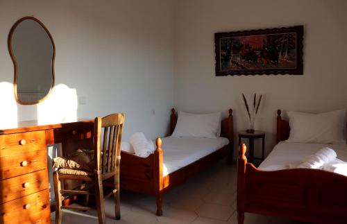 a bedroom with two beds and a desk and a mirror at Eleocharis near Amfilochia & Amvrakikos Gulf in Amfilochía