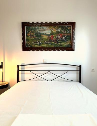 a bedroom with a bed with a painting on the wall at Eleocharis near Amfilochia & Amvrakikos Gulf in Amfilochía