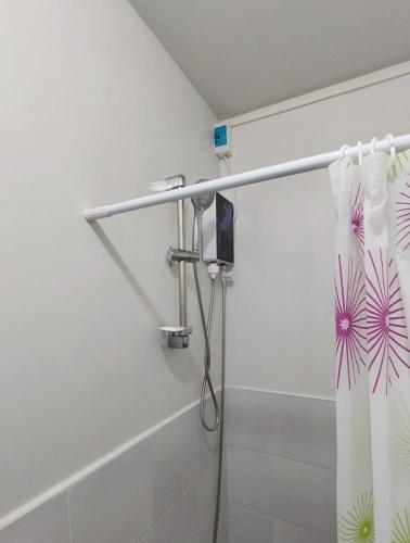 a shower with a shower curtain in a bathroom at Comfy WalkUp Studio Near Mactan Airport -Perfect for Travellers in Lapu Lapu City