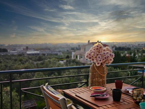 a table with a vase of flowers on a balcony at Olive Heaven in Kalamata