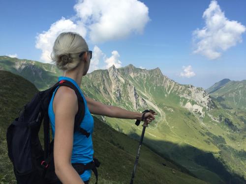 a woman with a backpack standing on top of a mountain at Gatterhof in Riezlern