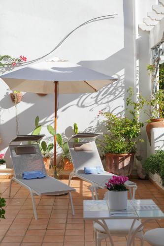 two chairs and an umbrella on a patio at Hotel Aurora in Sperlonga