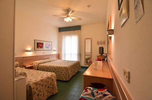a hotel room with two beds and a window at Hotel Aurora in Sperlonga