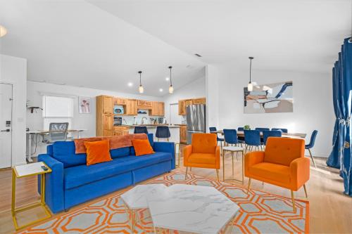 a living room with a blue couch and orange chairs at Family friendly - Fire pit -4 min to UF - Spacious in Gainesville