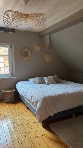 une chambre avec un lit et deux miroirs au mur dans l'établissement Charmante maison alsacienne proche Europa Park, à Ohnenheim