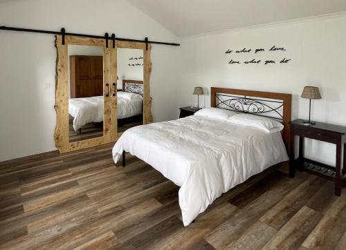 une chambre avec un lit et un grand miroir dans l'établissement Cozy Cottage, à Praia da Vitória