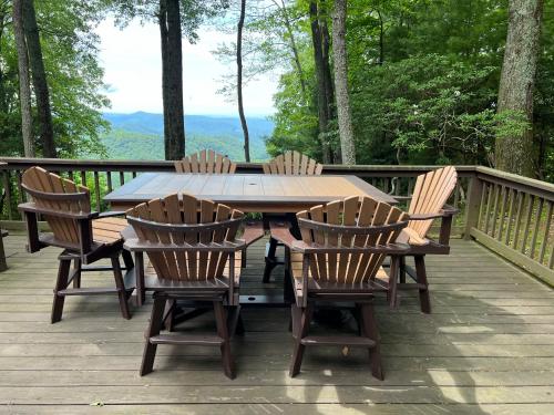 a wooden table and chairs on a deck at Log Cabin in Bailey Camp