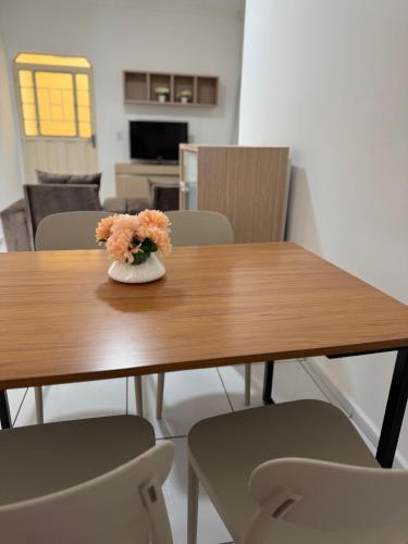 a wooden table with a vase of flowers on it at Meu Flat Temporada in Petrolina