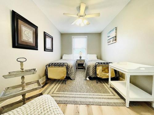 a bedroom with two beds and a ceiling fan at Pink Bungalow Downtown in Sandusky