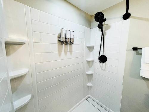 a white bathroom with a shower with at Pink Bungalow Downtown in Sandusky