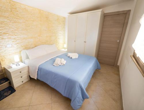 a bedroom with a blue bed with towels on it at Il Galante B&B casa vacanza in Ginosa