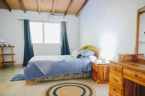 a bedroom with a bed and a window and a dresser at Casa Marea in Cambutal
