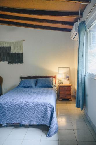 a bedroom with a blue bed and a window at Casa Marea in Cambutal