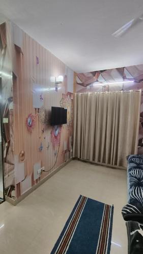 a living room with a tv and a room with a rug at Omaxe Eternity-Near Prem Mandir in Vrindāvan
