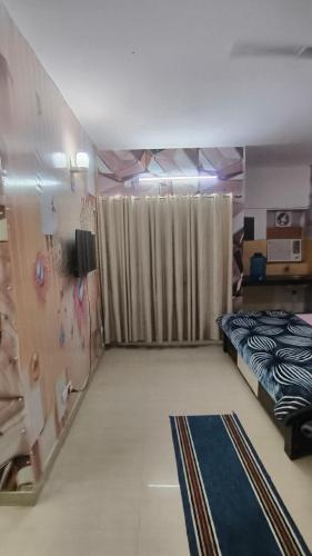 a room with a bed and a television in it at Omaxe Eternity-Near Prem Mandir in Vrindāvan