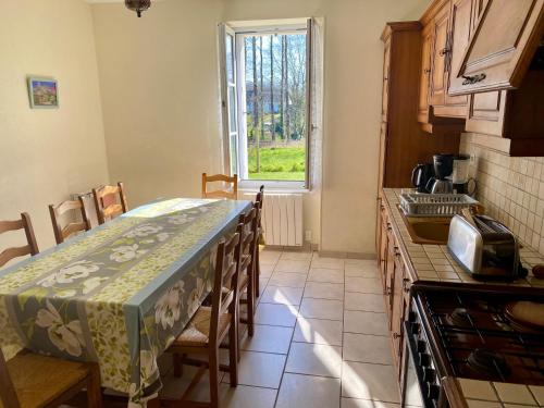 une cuisine avec une table et une table et une fenêtre dans l'établissement Maison à la Campagne à Melgven, à Melgven