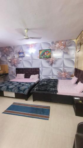 two beds in a room with purple walls at Omaxe Eternity-Near Prem Mandir in Vrindāvan