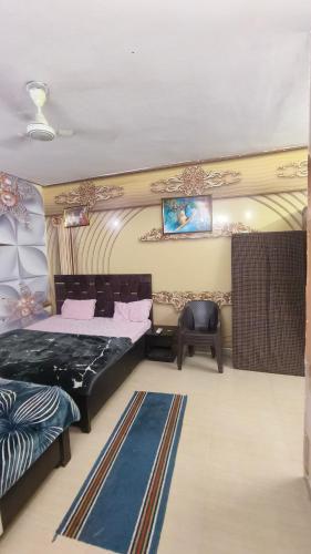a bedroom with two beds and a chair in it at Omaxe Eternity-Near Prem Mandir in Vrindāvan