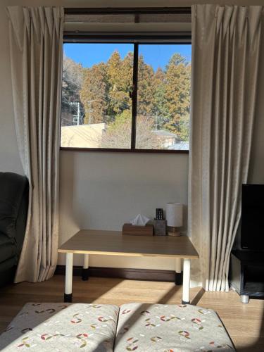 a room with a window with a bench and a table at 青梅森の宿 in Ome