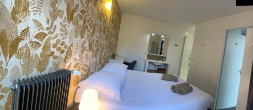 a bedroom with a bed with white sheets and a wallpaper at Le gauguin in Toulouse