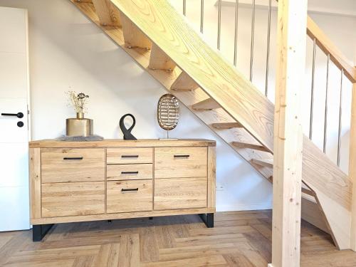 a wooden dresser in a room with stairs at EcoCube 3 Haren - Maisonette, 2Schlafzimmer, Waschmaschine in Bahnhof Haren