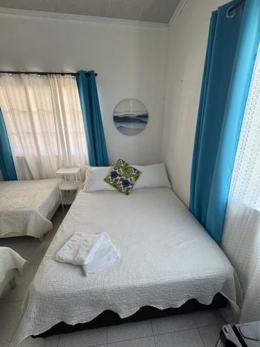 a bedroom with two beds and a blue curtain at Helena's Place in San Andrés
